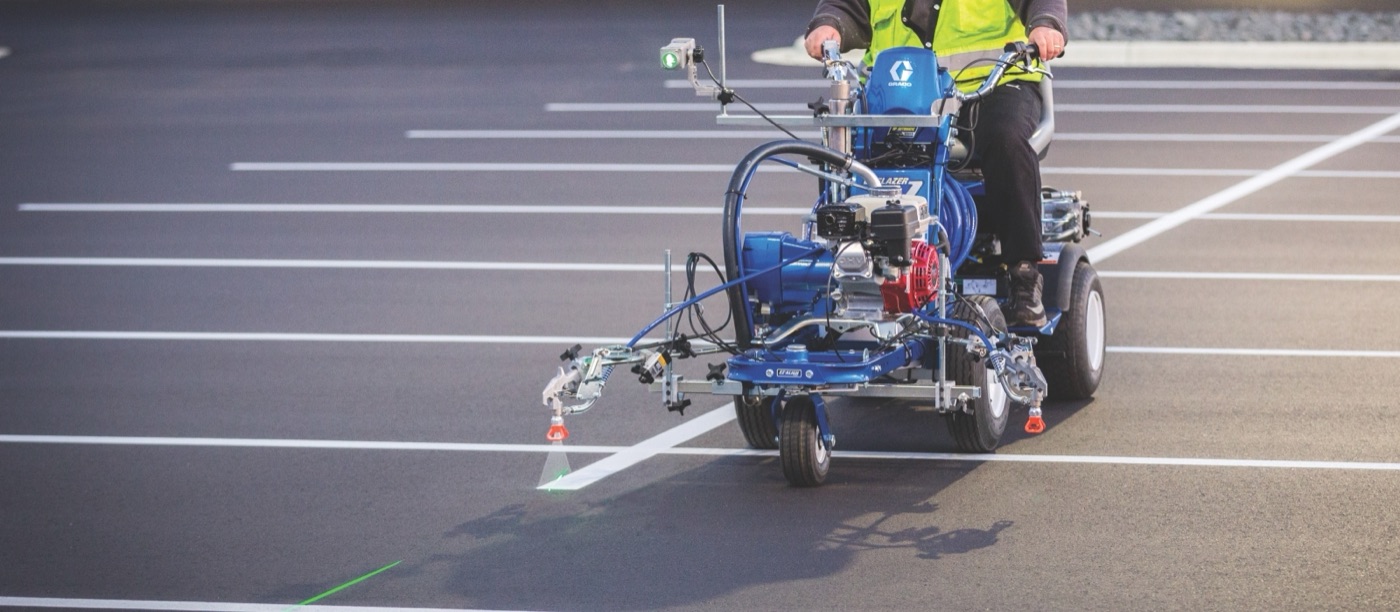 Line 1 Striping crew applying fresh paint with a Graco line striper